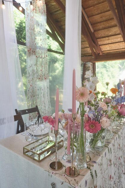 Foto floristiek bloemendecoratie van de bruiloft in pastelkleuren veel bloemen in verschillende vazen en vazen