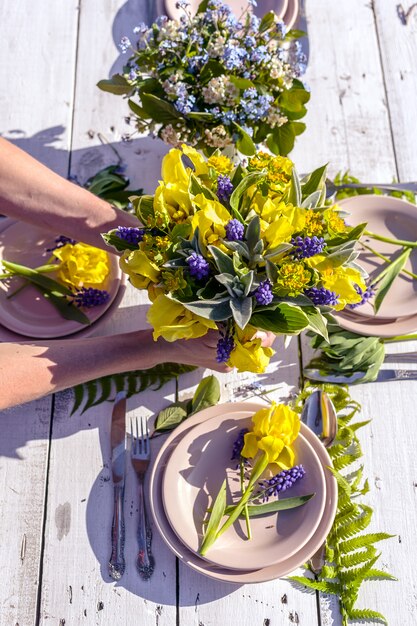 Foto i fioristi decorano con mazzi di iris gialli un matrimonio in stile rustico.