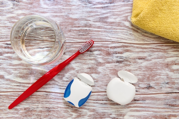 Floss, toothbrush, glass of water and towel, personal care items