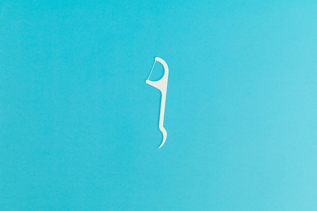 Photo floss with plastic handle on blue background