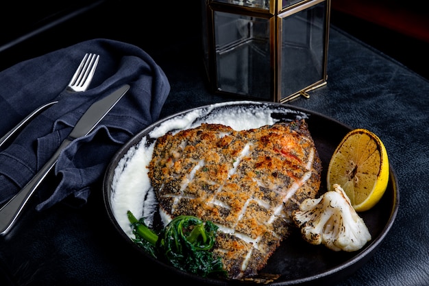 Flounder fillet roasted in a skillet with herbs and lemon