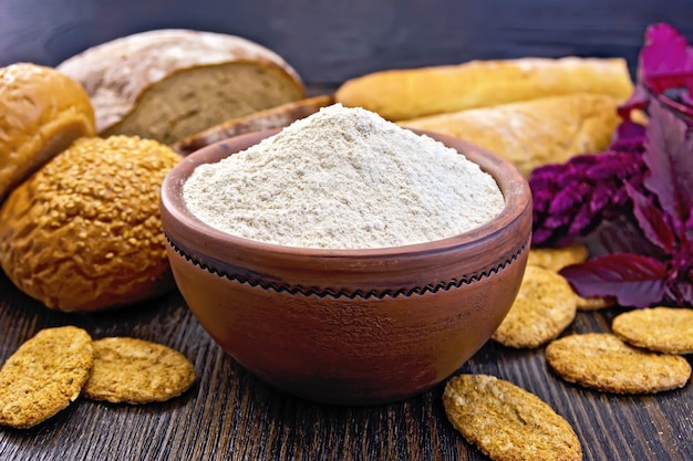 Flour amaranth in clay bowl with bread on board