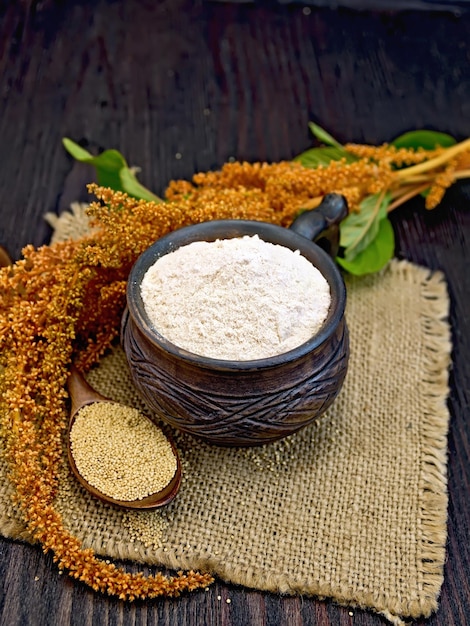 Photo flour amaranth in clay cup with flower on board