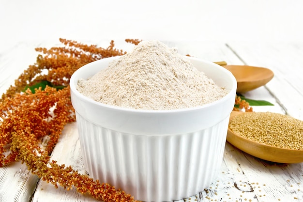 Flour amaranth in white bowl with spoon on board