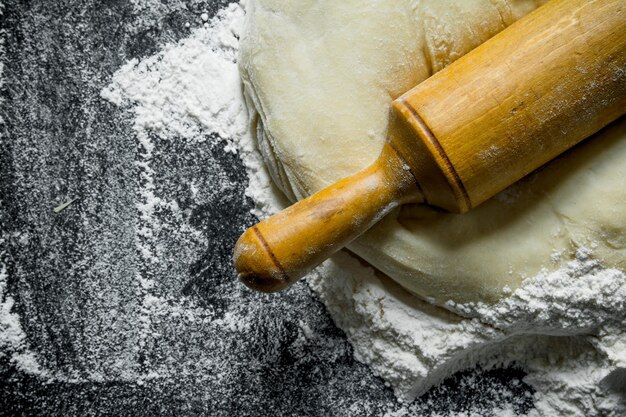 Foto sfondo di farina l'impasto con un mattarello