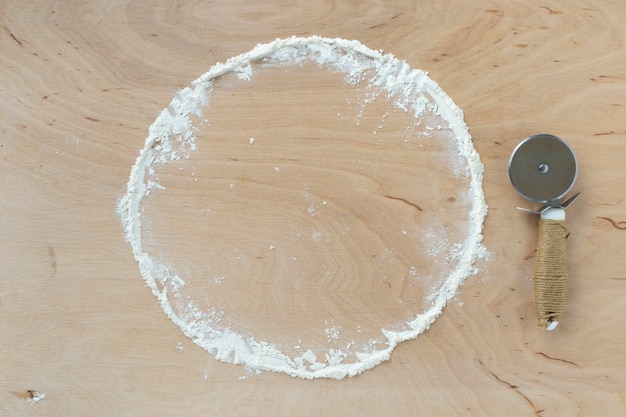 Flour powder sprinkled in circle on board