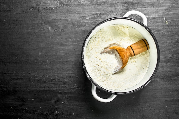 Flour in a saucepan. On the black chalkboard.