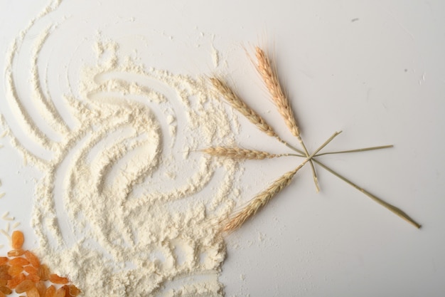 Flour, wheat, rice, raisins and coins on a white background