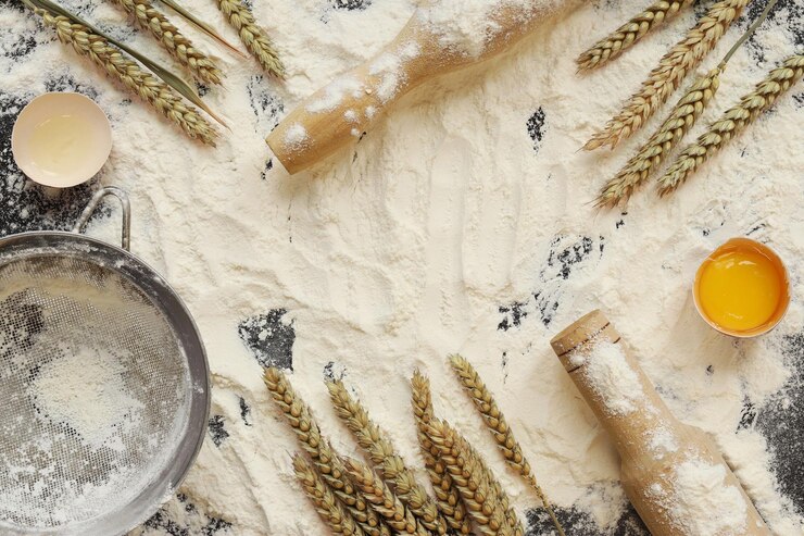 Flour with raw egg wooden rolling pin sieve and wheat ears Baking process background top view Cooking Heap of flour on dark table items for dough preparation Healthy home cooking concept