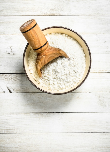 Photo flour with a scoop in a bowl.