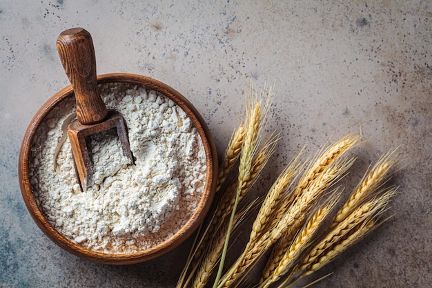 Flour in wooden bowl dark background