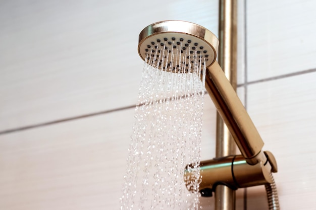 The flow of water from the watering can in the shower closeup Taking a shower