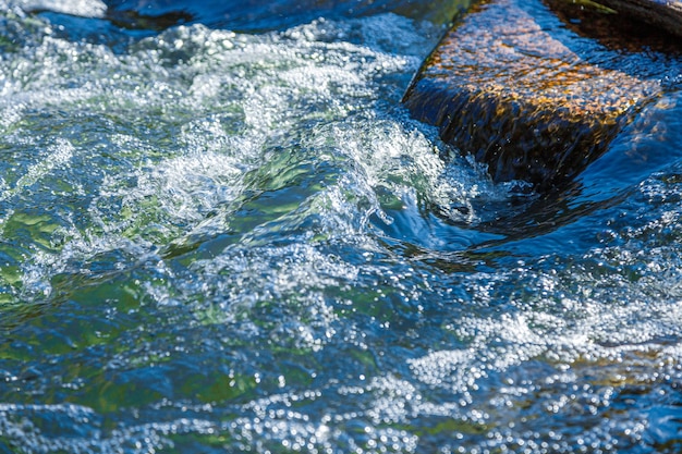 Flow of water and spray from a stone close up