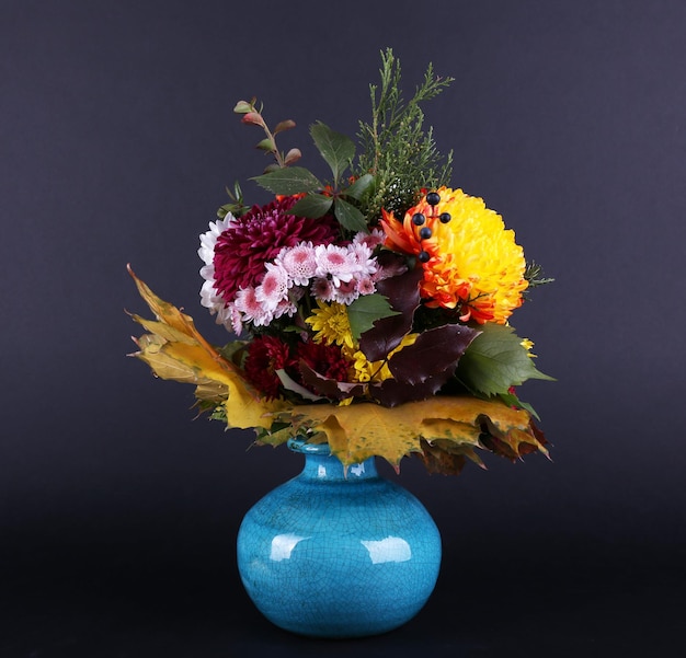 Flower bouquet in blue vase on dark grey background