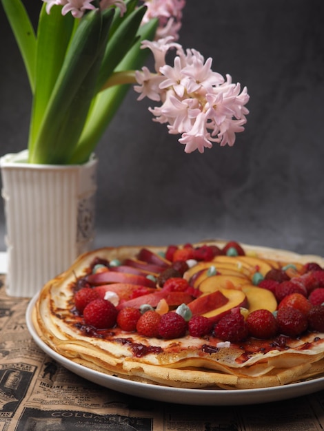 A flower next to a cake with fruit on it