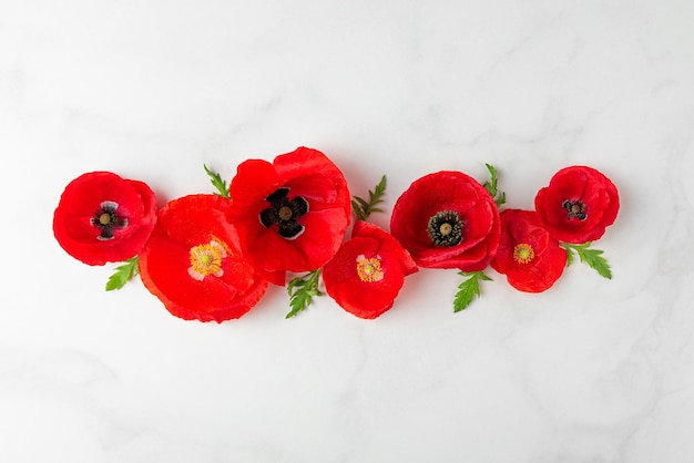 Foto composizione floreale fiori di papavero rosso su sfondo di marmo bianco posa piatta vista dall'alto sfondo di nozze