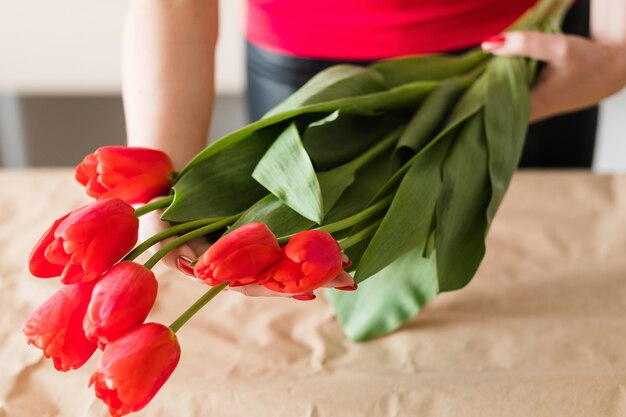 Flower delivery. florist holding a red tulip bouquet. spring festive bunch