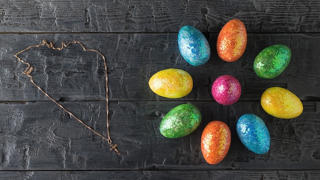 Flower of Easter eggs and decoration of gold on a dark wooden table The decoration of the Easter table