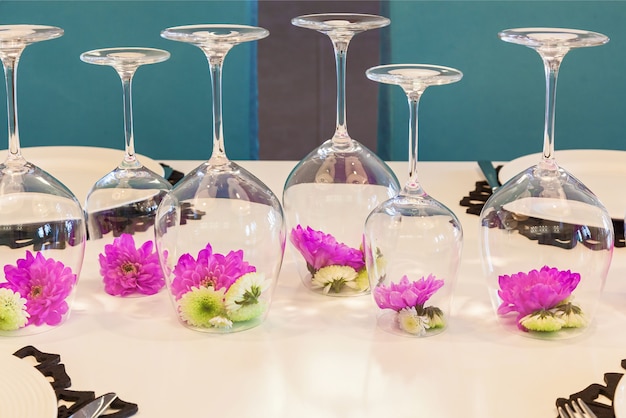 Flower of feulette chrysanthemum in an inverted glass on the table. decoration of a flower in a glass