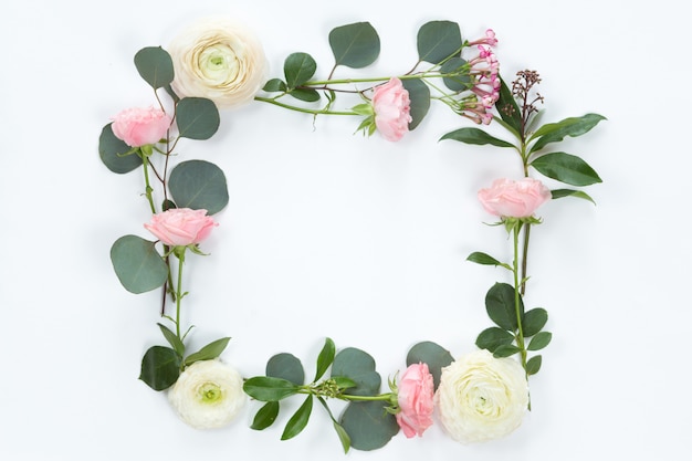 FLower frame with fresh branches of pion-shaped roses and eucalyptus leaves 