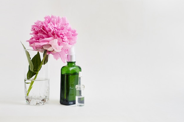 Flower and glass green vial with body oil.