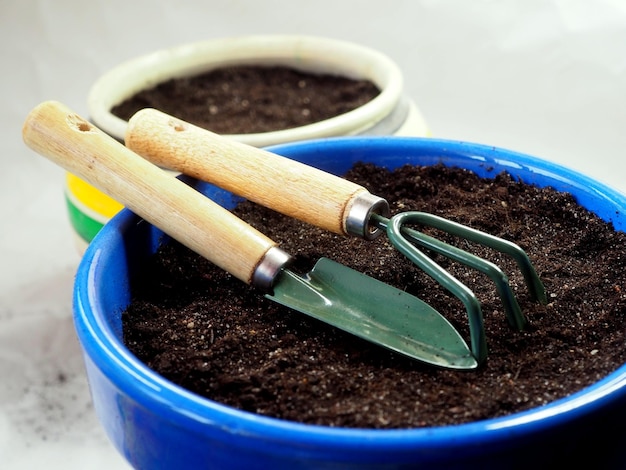 Flower pot with earth scoop and rake