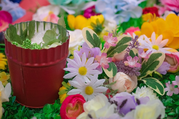 A flower pot with a red container with a flower in it.