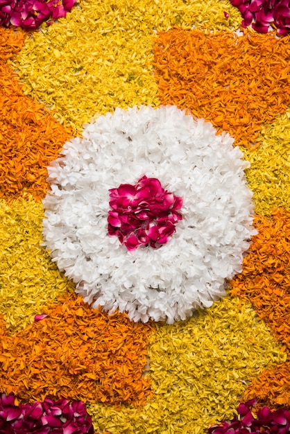 Foto rangoli di fiori per diwali o pongal o qualsiasi festival indù con fiori di calendula o zendu e petali di rose rosse, messa a fuoco selettiva