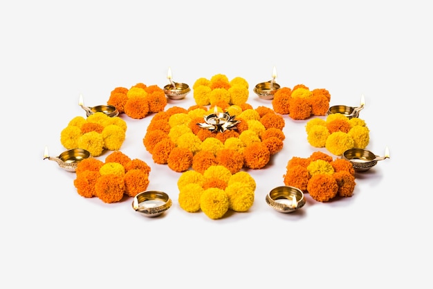Цветок Ранголи для фестиваля Дивали или Понгал, сделанный с использованием цветов календулы или зенду и лепестков роз на мрачном или белом фоне, выборочный фокус