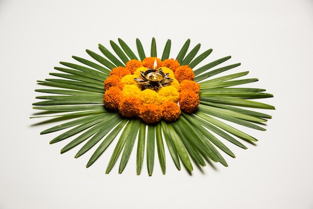 マリーゴールドまたはゼンドゥの花とバラの花びらを使用して作られたディワリ祭またはポンガル祭のフラワーランゴーリー、ムーディーまたは白い背景、選択的なフォーカス