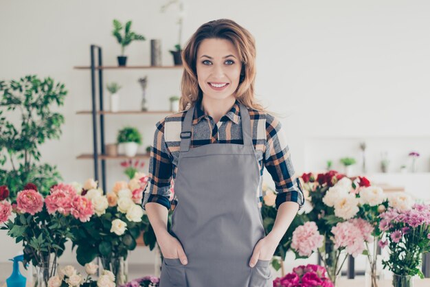 Flower shop owner posing surrounded by flowers