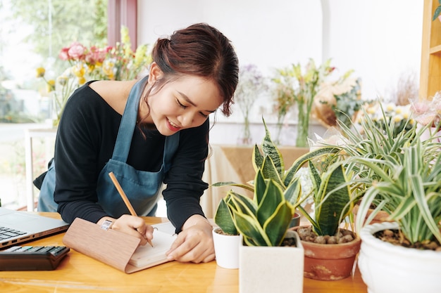 Flower shop owner writing in planner