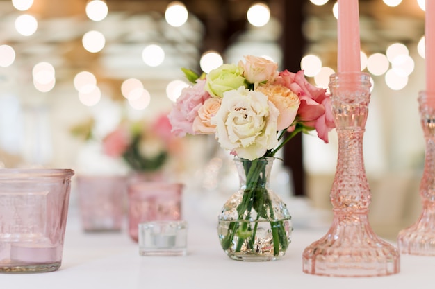 Flower table decorations for holidays and wedding dinner. Table set for holiday wedding reception in outdoor restaurant.