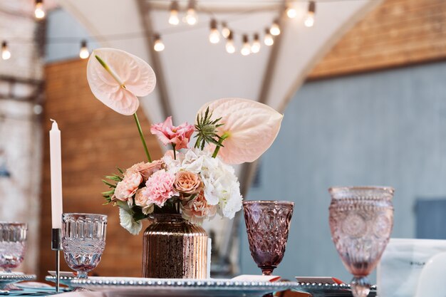 Flower table decorations for holidays and wedding dinner. Table set for holiday wedding reception in outdoor restaurant.