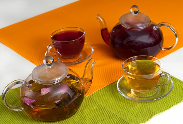 Flower tea in clear glass teapots with teacups