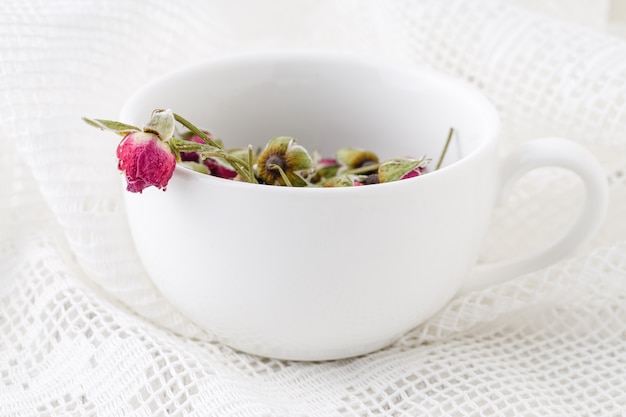 Flower tea rose buds on old wooden table