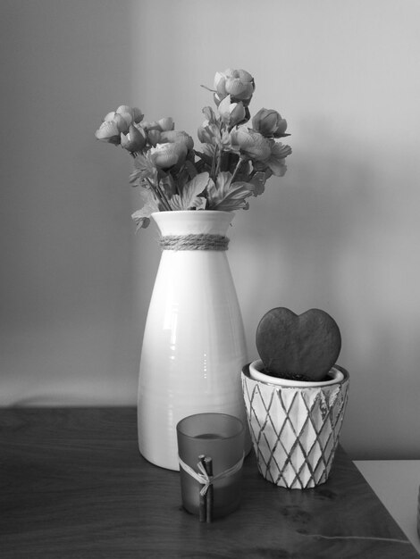 사진 벽 에 맞대고 있는 테이블 에 있는 꽃병 과 장식