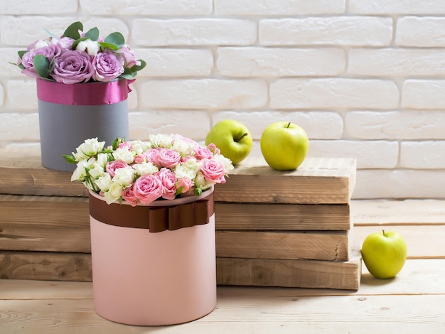 Flowers and apple on wooden planks