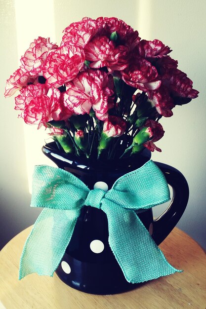 Photo flowers arranged in vase on table at home