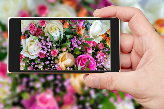 Foto bellissimo bouquet di fiori sullo schermo dello smartphone. sfondo naturale floreale decorativo.