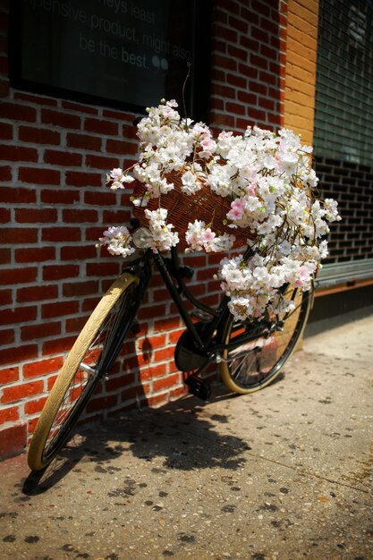 Foto fiori su una bicicletta contro un muro di mattoni