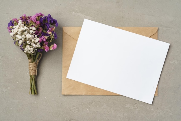 Flowers blank paper and envelope on a table top