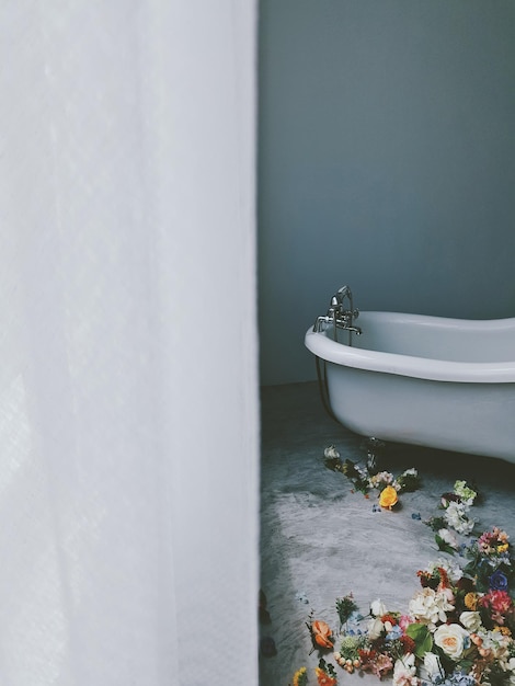 Flowers by bathtub in bathroom