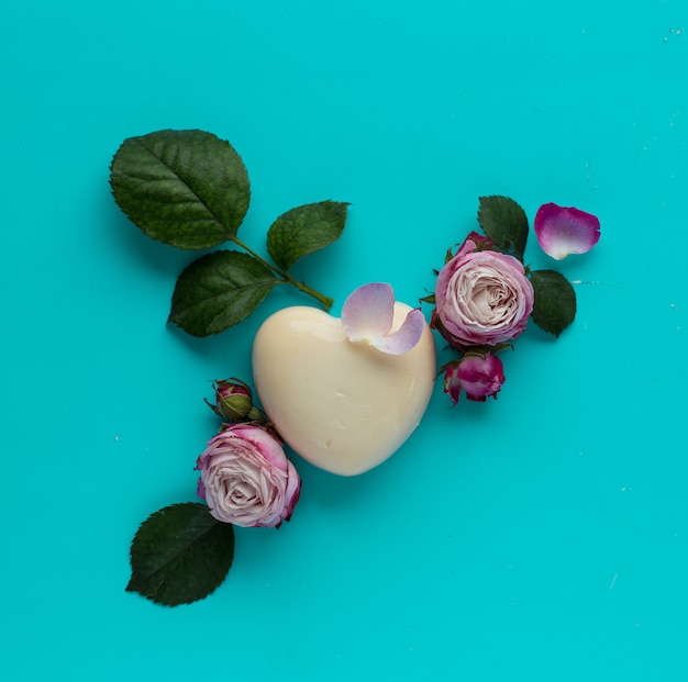 Flowers and cake in shape of heart in flat lay style