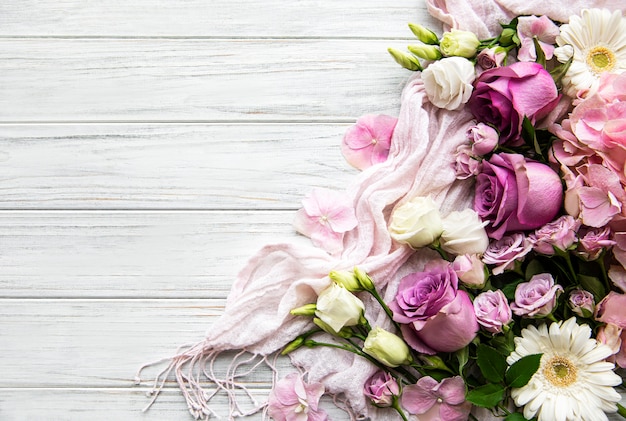 Flowers composition. Border made of pink flowers on white wooden.