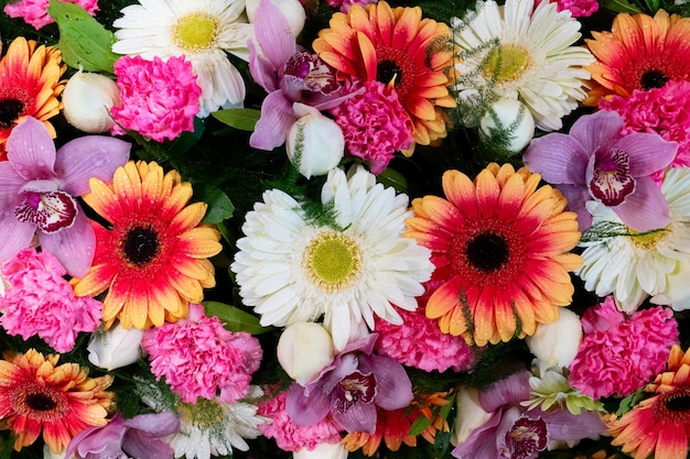 Flowers composition floral wall texture made of fresh roses orchids and herbera flowers