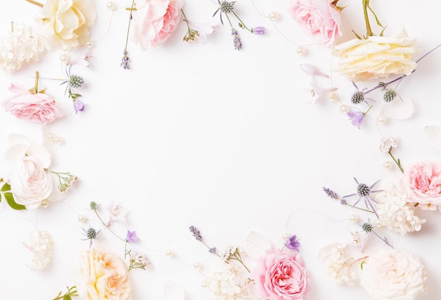 Photo flowers composition frame made of pink rose flowers on white background flat lay top view