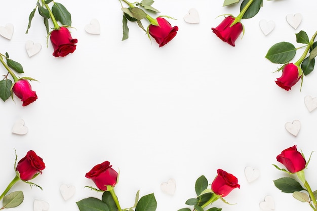 Flowers composition. Frame made of red rose on white background. Flat lay, top view.