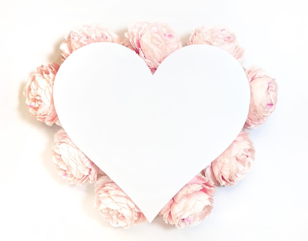 Photo flowers composition from pink flowers in the form of a heart on white background spring summer