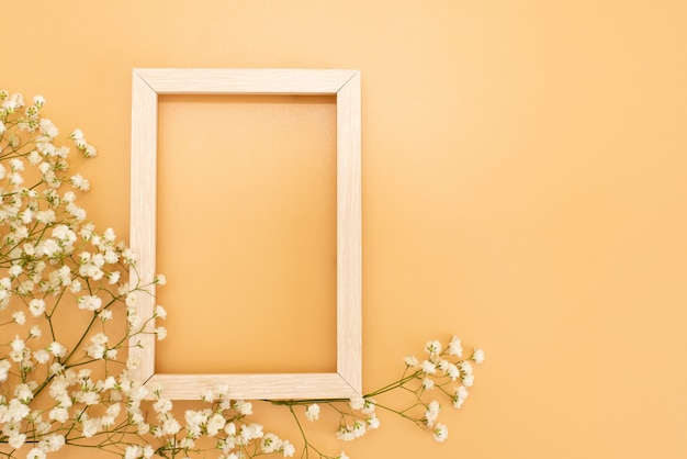 Flowers composition romantic. white gypsophila flowers, photo frame on pastel pink background.